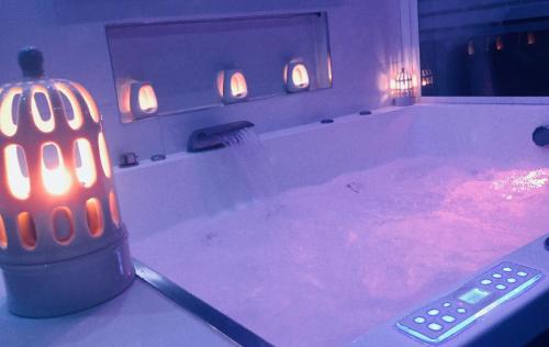 博讷Appart' Spa et Sauna Privatif Au Cœur De Beaune的蜡烛浴缸中的遥控器