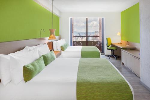 布卡拉曼加Hotel Bari Bucaramanga的酒店客房配有两张床和一张书桌