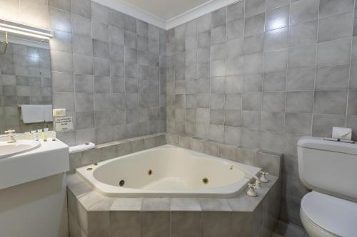 西怀厄朗Club Inn Motel的带浴缸、卫生间和盥洗盆的浴室