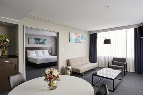 墨尔本墨尔本亚当湾景酒店的酒店客房设有床和客厅。