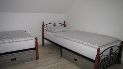 Ivančna GoricaDom Vita Sticna的白色墙壁客房中的两张单人床