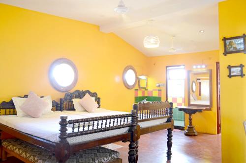 蓬蒂切里A La Villa Creole的一间卧室设有一张黄色墙壁的床