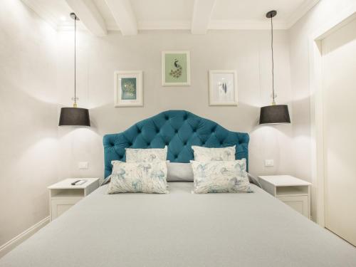 蒙特罗索阿尔马雷A cà da Alba Rooms的一间卧室配有一张大床和蓝色床头板