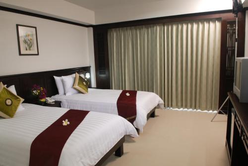查汶First Residence Hotel的酒店客房设有两张床和电视。