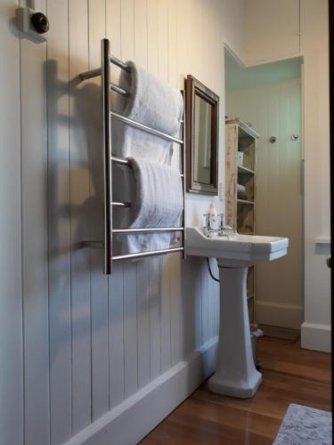 奥玛鲁The Wansbeck的浴室配有盥洗盆、镜子和毛巾
