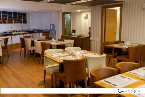 埃斯基谢希尔GRAND ŞAH OTEL的一间带桌椅的餐厅和一间厨房