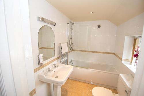 塞尔诺曼赫斯特酒店的白色的浴室设有浴缸、水槽和卫生间。
