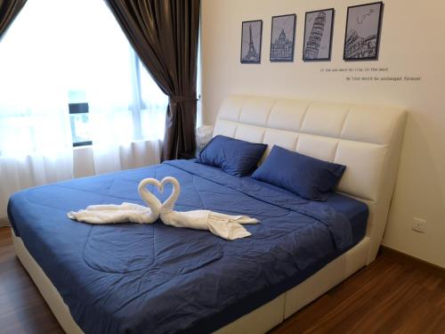 吉隆坡Luxury Resort Suite Kuala Lumpur@5mins to Mid Valley, Sunway的一间卧室配有一张床铺,床上铺有天鹅毛巾