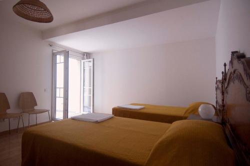 塞辛布拉Casa da Tia Matilde的一间卧室设有两张床和大窗户