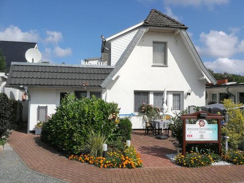 青斯特Zingster Ostseeklause的前面有标志的白色房子