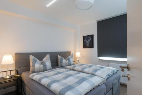 本讷肯施泰因Harzer-Bachtaeler的一间卧室配有一张带蓝白色布艺毯的床