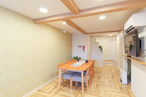 金泽Higashiyama Chitaru in Kanazawa的一间带木桌和椅子的用餐室