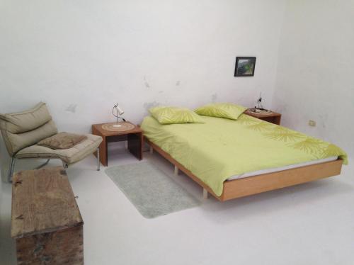 阿索马达Patio I的一间卧室配有一张大床和一把椅子