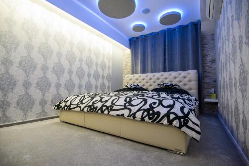捷克捷欣Wellness Apartmán Relax的一间卧室配有一张蓝色天花板的床
