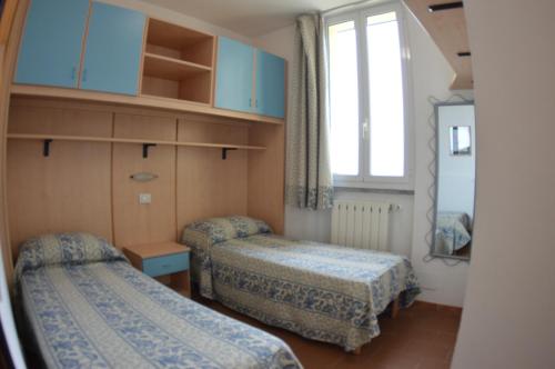 阿尔本加Residence Villa Miky的小房间设有两张床和窗户