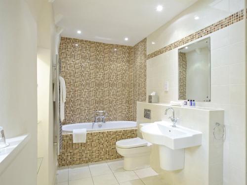 利文斯顿麦克唐纳德豪斯顿别墅酒店的浴室配有盥洗盆、卫生间和浴缸。