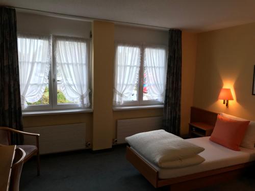 欧博比皮Hotel Eintracht的一间卧室设有一张床和两个窗户。