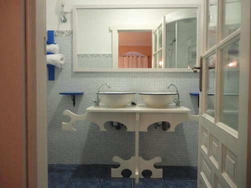 BrazatortasHotel Rural las Cinco Ranas的浴室设有2个水槽和镜子