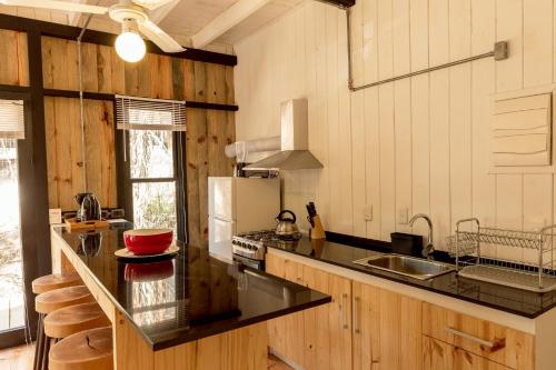 何塞伊格纳西奥Zulu Beach的厨房配有黑色台面和冰箱