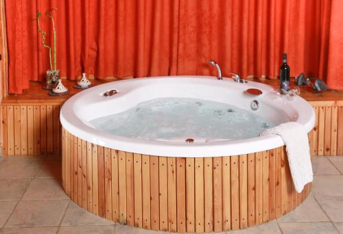 Neot Golan水中天酒店的一个带红色窗帘的房间的热水浴缸