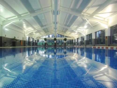 惠特彻奇麦克唐纳德山谷高尔夫Spa酒店的铺有蓝色瓷砖的大型游泳池
