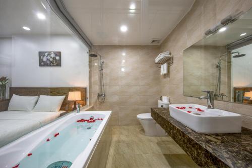 河内Granda Suites Hanoi的带浴缸、床和盥洗盆的浴室