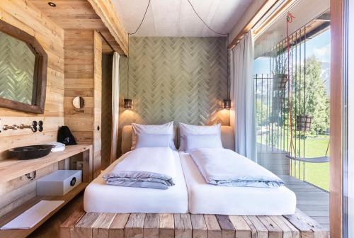 玛丽亚阿尔姆HOTEL SEPP - Alpine Boutique Hotel - Adults Only的一间带两张床的卧室和一个阳台