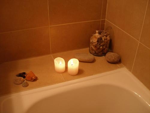 莱里达Hotel Reina Isabel的两把蜡烛坐在浴缸的边缘
