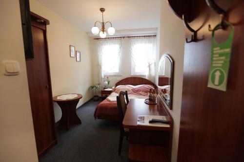 沃尔什滕考卡斯酒店的酒店客房设有一张床铺、一张桌子和一间卧室。