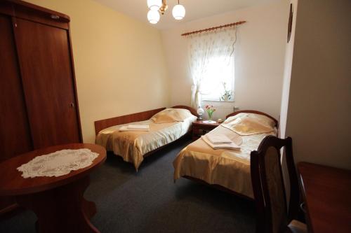 沃尔什滕考卡斯酒店的客房设有两张床、一张桌子和一扇窗户。