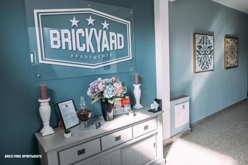 克卢日-纳波卡Brickyard Apartments Cluj的梳妆台上花卉墙上的标志