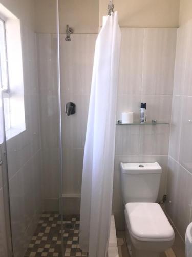 德班Concord Christian Guesthouse的浴室设有卫生间和带浴帘的淋浴。