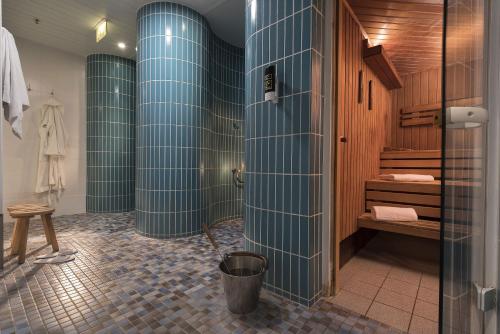 柏林玛丽蒂姆柏林普洛艾特酒店的带淋浴的浴室和蓝色瓷砖墙壁