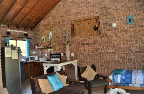 圣卢西亚St Lucia Wilds的一间设有砖墙和桌椅的房间