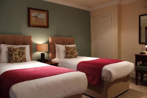 布兰博罗迪宾斯代尔旅馆的酒店客房带两张红色和白色的床单