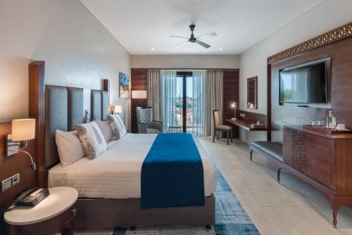 桑给巴尔Hotel Verde Zanzibar - Azam Luxury Resort and Spa的酒店客房设有一张大床和一台电视。