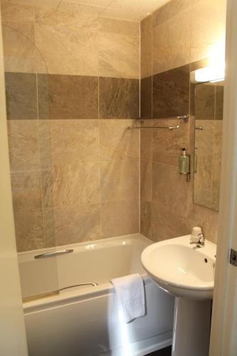 布兰博罗迪宾斯代尔旅馆的一间带水槽、浴缸和卫生间的浴室