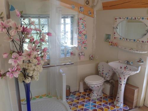 卡罗la maison bleue的浴室设有卫生间、水槽和花瓶。