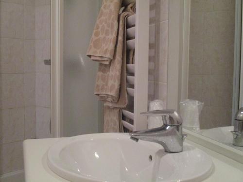 CrouzillesAuberge "AU BON ACCUEIL"的浴室配有盥洗盆、淋浴和毛巾
