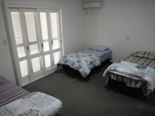 南圣克鲁斯CASA JE - Santa Cruz do Sul的带两张床的房间和一扇窗户的门