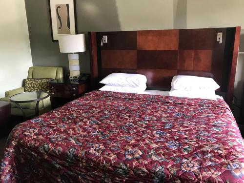 中心城市CCI Express Inn的一间卧室配有一张带红色毯子的大床