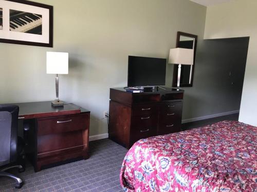 中心城市CCI Express Inn的酒店客房配有一张床、梳妆台和书桌