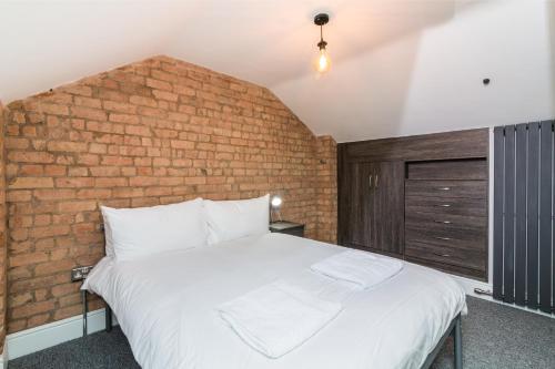 朗伊顿Salisbury Street Guesthouse的砖墙房间的一个床位