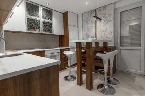 贝尔格莱德新城国际公寓式酒店的厨房配有柜台和凳子
