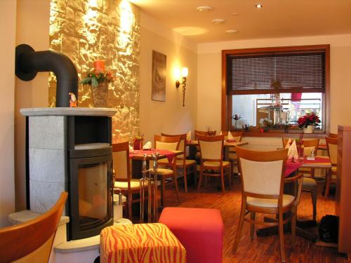 Kirchhatten德国之家酒店及餐厅的一间带壁炉和桌椅的餐厅