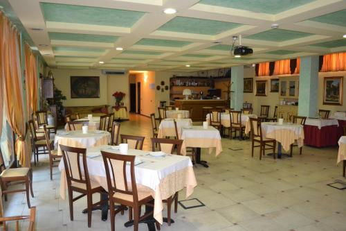 Ghedi阿尔伯格皮亚纳酒店的一间在房间内配有桌椅的餐厅