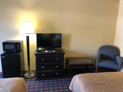 莫米美洲最佳价值旅馆莫米/托莱多的酒店客房配有一张床、一台电视和一把椅子