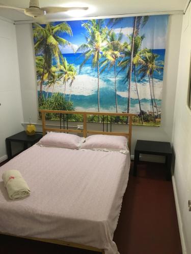 飞鱼湾Ocean View Apartments的一间种植了棕榈树的壁画的卧室