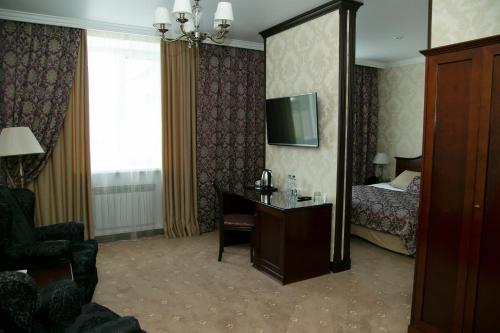 托木斯克论坛酒店的酒店客房设有一间带一张床和一张书桌的卧室