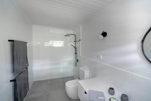 苦难角mist at Cape Tribulation的白色的浴室设有卫生间和镜子